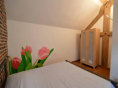 a bedroom with a bed and a flower mural on the wall at Teuven Farmhouse for 24 Guests in Teuven