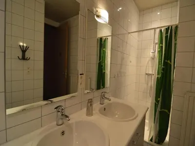 a white bathroom with a sink and a mirror at Teuven Farmhouse for 24 Guests in Teuven