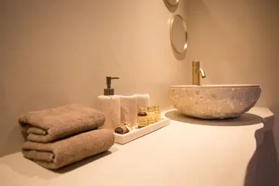 a bathroom with a bowl sink and towels on a counter at Ontspan huisje: wellness in de natuur in Lanaken