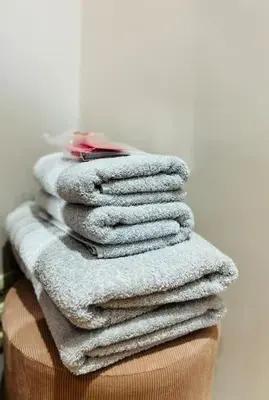 a stack of towels sitting on top of a basket at Charmant petit appartement. in Liège