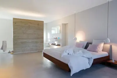 a bedroom with a bed with white sheets and pink pillows at B&B Opus35 in Montzen