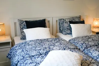 two beds with blue and white blankets and pillows at Boshuisje De Eekhoorn in Lanaken