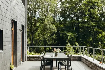 a patio with a table and chairs on a balcony at Au pied du Pré by WelcHome in Verviers