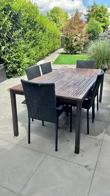 a wooden table with four chairs around it at Stylish Home near Maastricht Alicias house in Lanaken