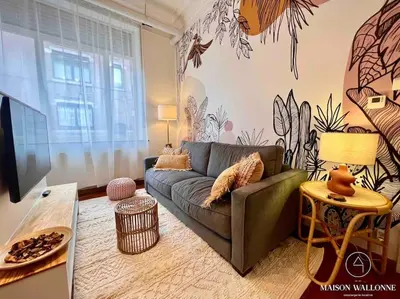 a living room with a couch and a table at Le cocon rose - Chic, proche Jardin botanique in Liège