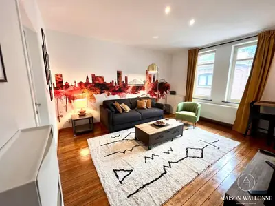 a living room with a couch and a rug at Le Loft liégeois - Au coeur de la cité in Liège