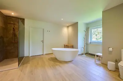 a large bathroom with a tub and a shower at Villa Bosrijk in Lommel