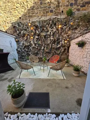 a patio with chairs and a wall with lights at Maison du Roi in Liège