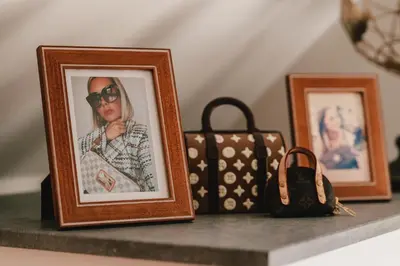 a shelf with three framed pictures and a purse at Maison Idyllique in Bree