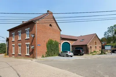 a brick building with a car parked in front of it at Apartment 't Maanhof in Gingelom