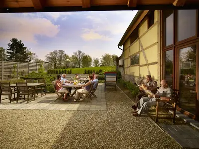 a group of people sitting at tables on a patio at Apartment 't Maanhof in Gingelom