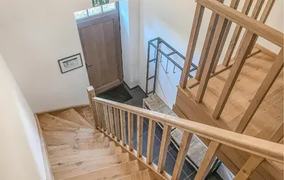 a wooden staircase with a wooden door in a house at Looshof in Helchteren