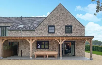 a brick house with a wooden pavilion with two benches at Looshof in Helchteren