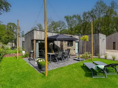 a backyard with a table and an umbrella at Thalor in Zutendaal