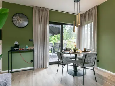 a dining room with green walls and a table and chairs at Thalor in Zutendaal