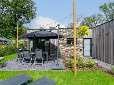 a patio with a table and an umbrella at Thalor in Zutendaal