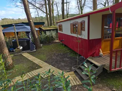 a red and white tiny house in a yard at pipowagen met prive Hot tub in Lanaken