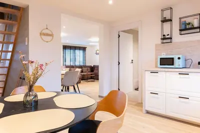 a kitchen and living room with a table and chairs at Stijlvol appartement met jacuzzi & sauna in Herk-de-Stad