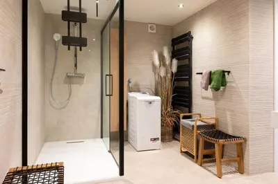 a bathroom with a walk in shower and a refrigerator at Stijlvol appartement met jacuzzi & sauna in Herk-de-Stad