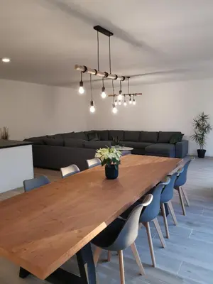 a dining room with a wooden table and chairs at Ten Velde - vakantiewoning 12 personen - sauna - bubbelbad in Hoeselt
