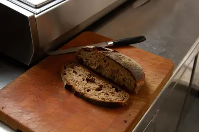 two slices of bread on a cutting board with a knife at Hotel Het Menneke in Hasselt