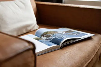 a book with glasses on top of it on a couch at Hotel Het Menneke in Hasselt