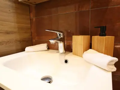 a bathroom sink with a faucet and towels on it at Sonnig Bungalow in Lanaken