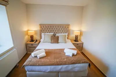 a bedroom with a large bed with two lamps at Hôtel Au Comte de Mercy in Oupeye