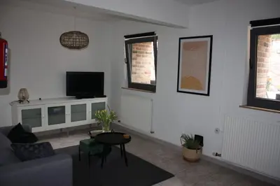 a living room with a couch and a tv at De Millenniumhoeve (Jean) in Riemst
