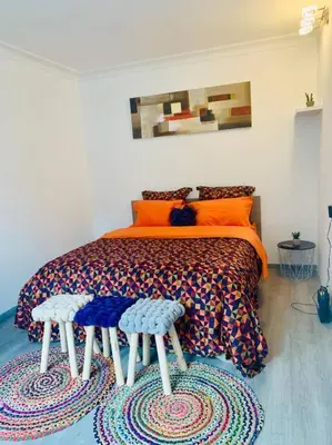 a bedroom with a bed with two stools on it at Appartement très proche médiacité - centre ville in Liège