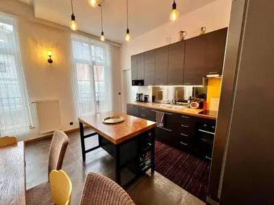 a kitchen with a wooden table in a room at Art Loft -Opéra, Saint-Lambert, Bueren in Liège