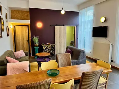 a living room with a table and chairs at Art Loft -Opéra, Saint-Lambert, Bueren in Liège