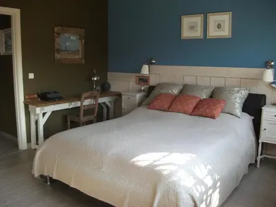 a bedroom with a large bed with a desk and a desk at Apartment Het Demerhuisje in Hasselt