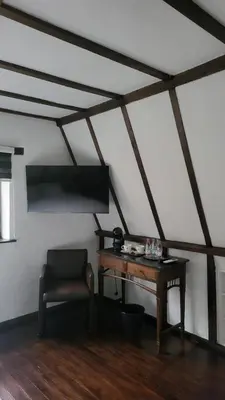 a room with a desk and a chair in a attic at De Pelgrim in Tongeren