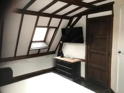 a room with a dresser and a window and a door at De Pelgrim in Tongeren
