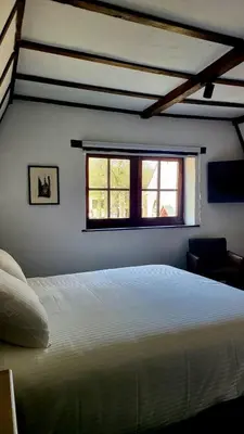 a bedroom with a white bed and a window at De Pelgrim in Tongeren