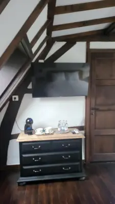 a black dresser in a room with a staircase at De Pelgrim in Tongeren