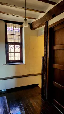 an empty room with a window and a wooden door at De Pelgrim in Tongeren