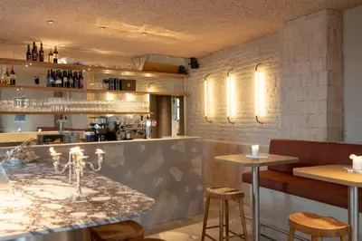 a bar with a marble counter and stools at Luxe in Het Posthuis - nieuwe Stijlvolle Verblijven in Oud-Rekem in Lanaken