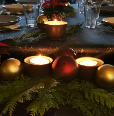 a table with lit candles and christmas decorations on it at Huisje Mezengroet in Lanaken