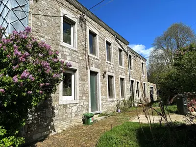 an old brick building with flowers in front of it at Close from Ardenne - Fully renovated modern farmhouse in Baelen in Baelen