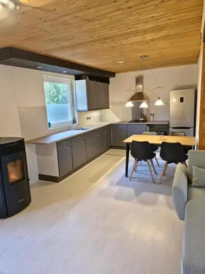 a kitchen and living room with a table and chairs at Cozychalet met prive Hot tub in Lanaken