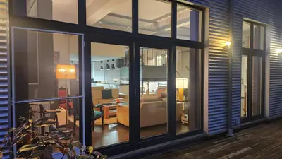 a living room with glass windows and a couch at Superbe loft de caractère avec garage à 10' du centre in Liège