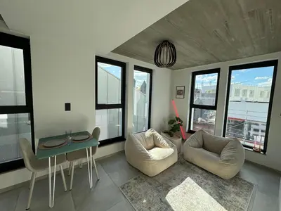 a living room with a table and chairs and windows at PentHouse 5.01 in Liège