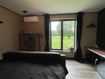 a bedroom with a bed and a large window at Tranquilo Maaseik in Maaseik