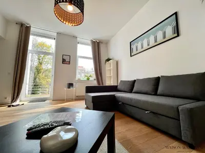 a living room with a couch and a table at Le Botanique des Augustins -100m2 en plein centre in Liège