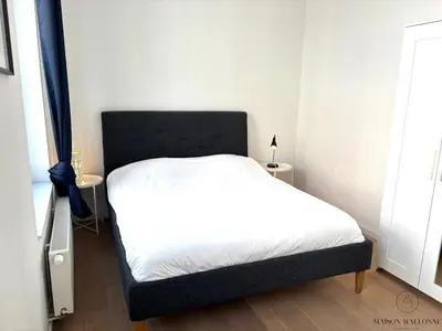 a bedroom with a bed with a black headboard at Le Botanique des Augustins -100m2 en plein centre in Liège