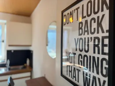 a kitchen with a door with a sign that says dont look back youre coming at Le parfait Studio de la Cité Ardente - Central in Liège