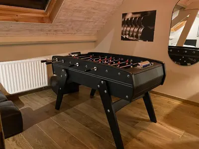 a black foosball table in the corner of a room at La réserve by la Villa KerKus in Fraipont