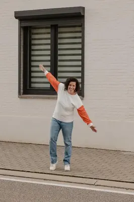 a woman standing on a sidewalk with her arm in the air at Alivio - Thuiskomen bij jezelf op vakantie in Lummen